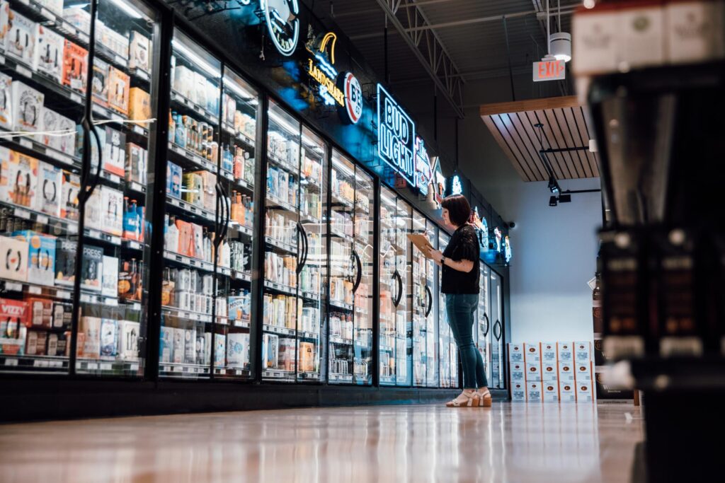 Woman Standing with a Clipboard in a Liquor Store Aisle
