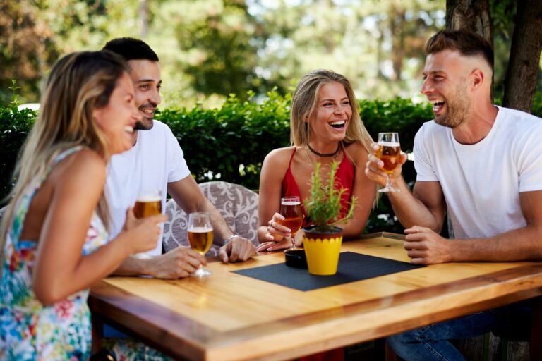 Happy customers sitting on the patio and enjoying beers at a brewery